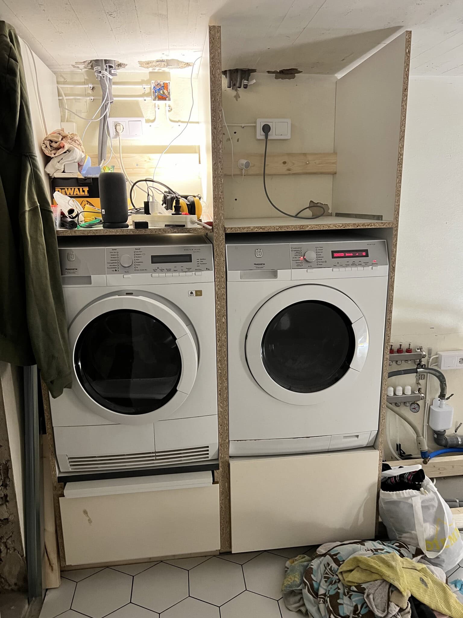 Tvättmaskiner installerade med utdragbar hylla och låda.