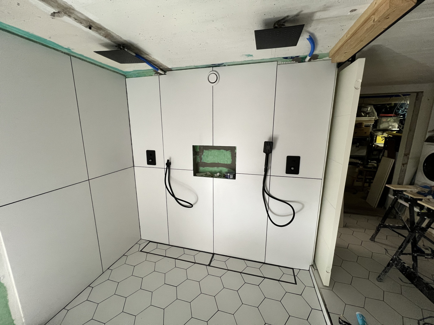 Duschområde med pågående renovering och installation av duschutrustning.